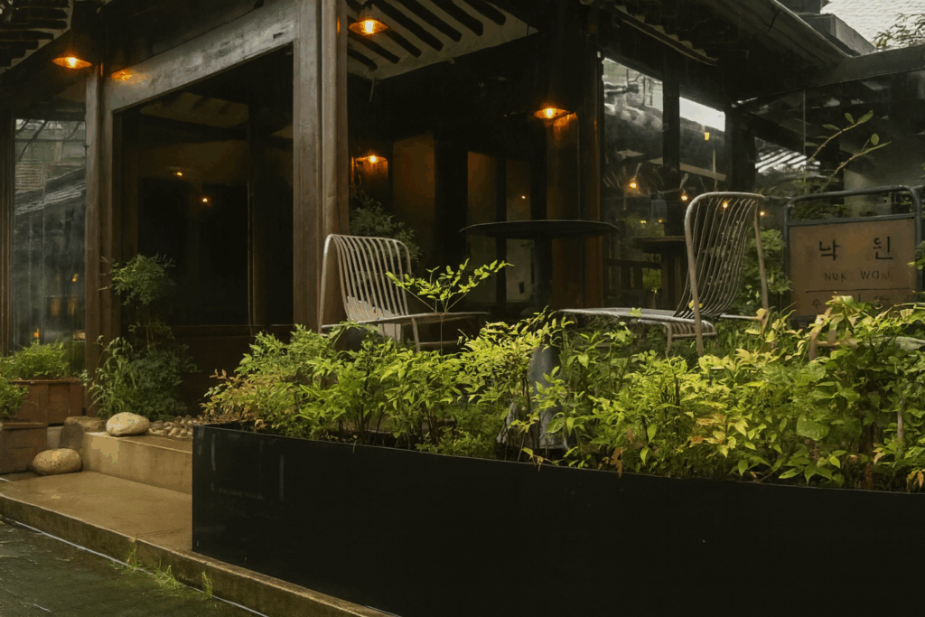 雨の益善洞にある韓屋カフェの外観とテラス席。緑に囲まれた静かな雰囲気が魅力の人気スポット。